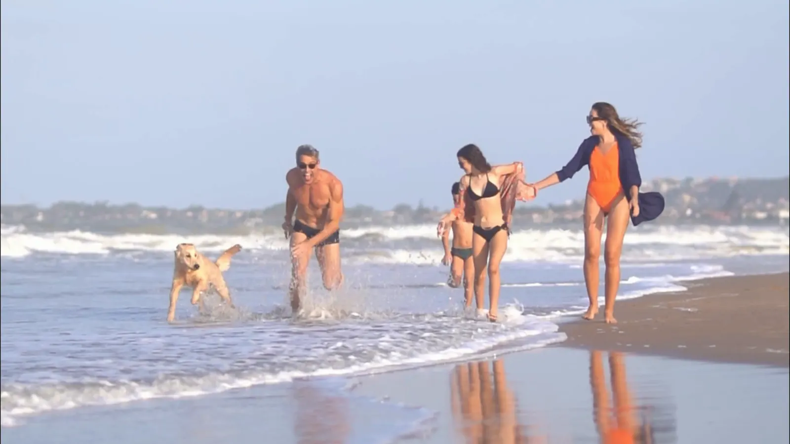 Família correndo na beira da praia