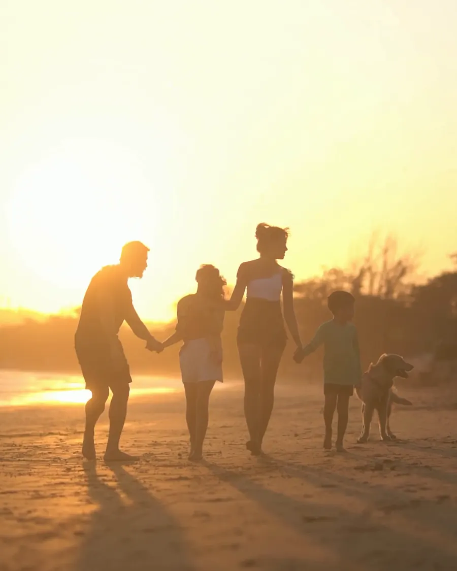 Família na praia ao pôr do sol
